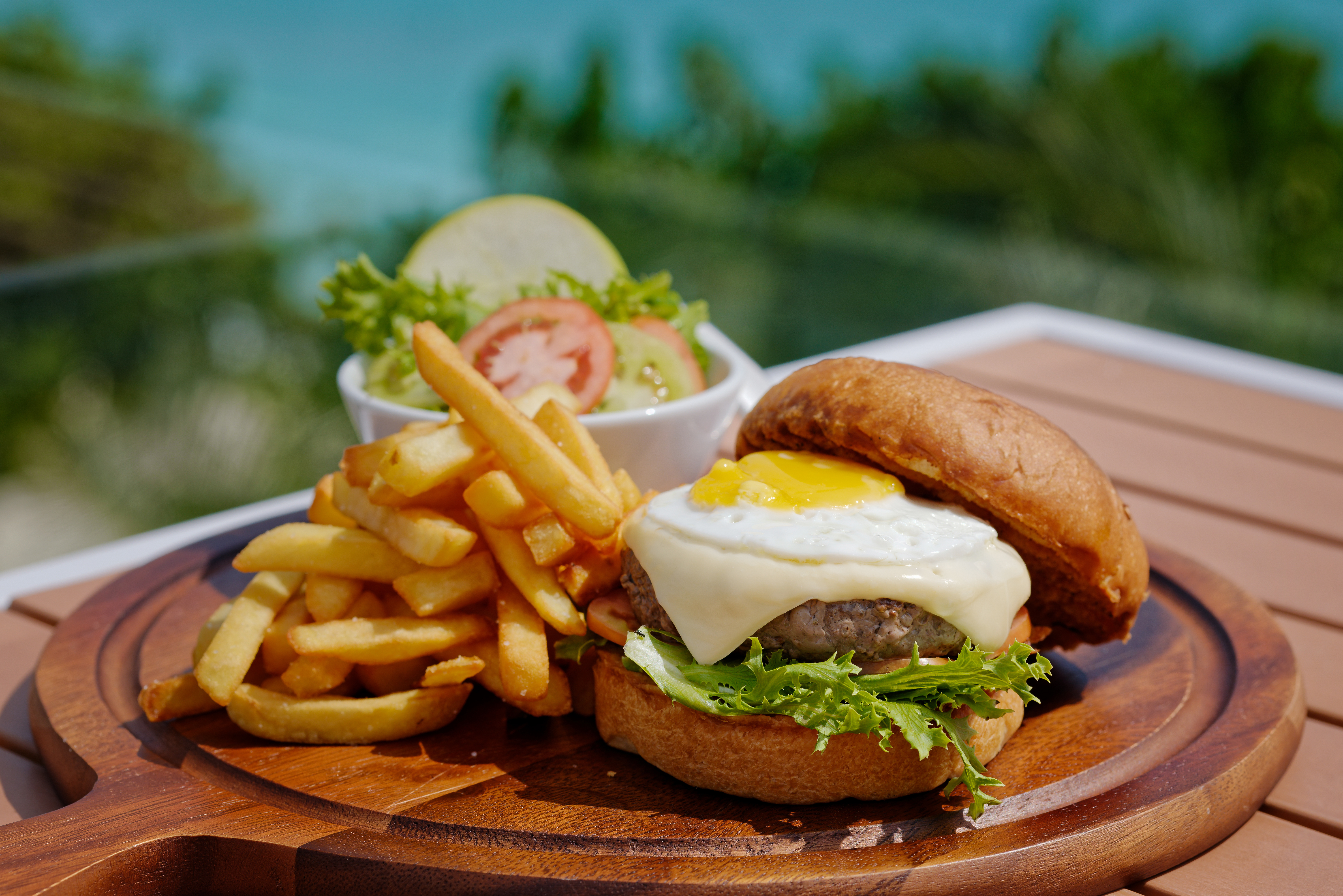 Rooftop cheeseburger with fried egg, hand-cut fries and side salad at Luau Restaurant